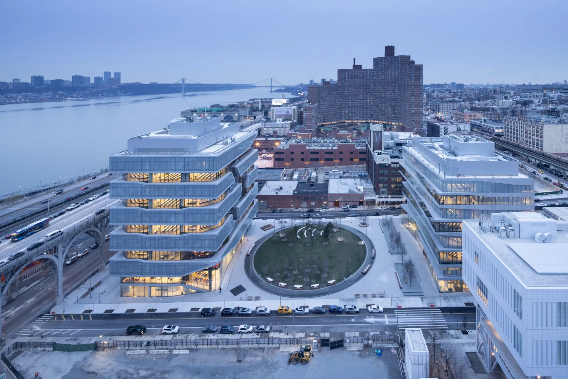 A view of Columbia Business School during dusk with upper Manhattan and the Hudson River in the background.