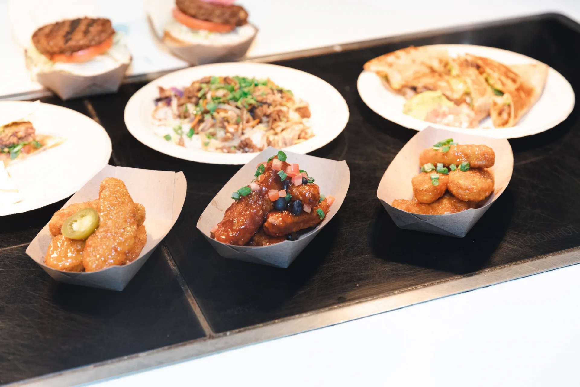 A selection of different meals prepared with Beyond Meat, including chicken tenders, quesadillas, a rice bowl, burgers, and more.