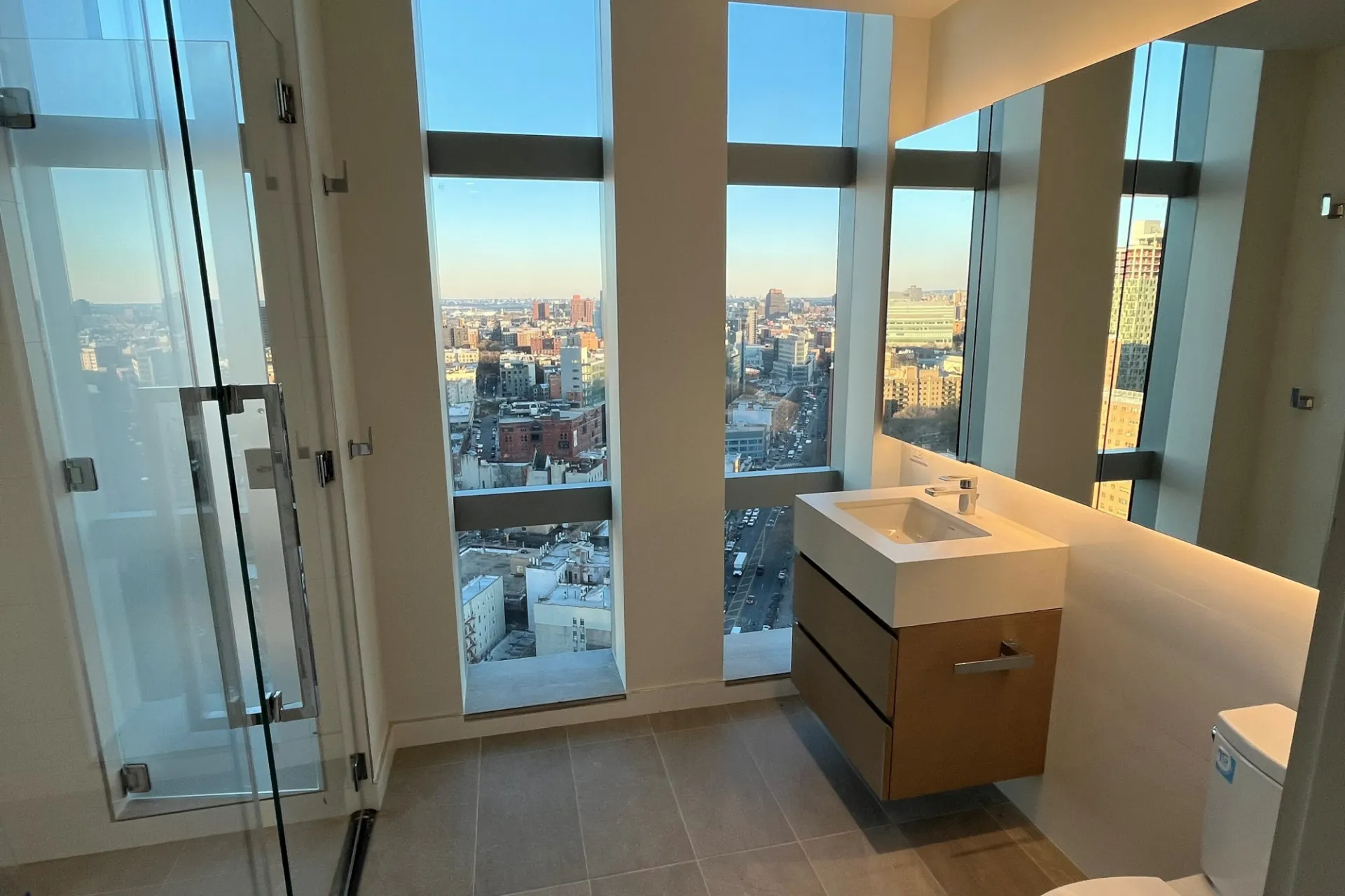 A new bathroom with floor to ceiling windows overlooking Harlem.