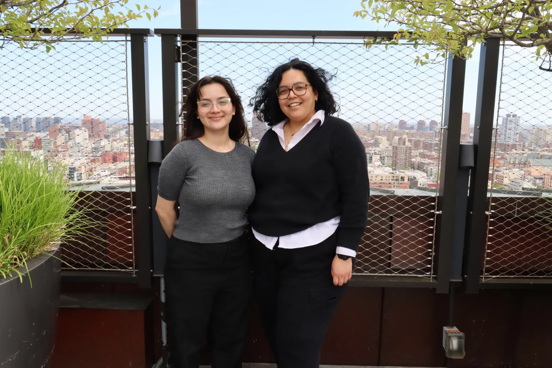 Daphne Mendez and Ashly Medina stand on a terrace that overlooks West Harlem.