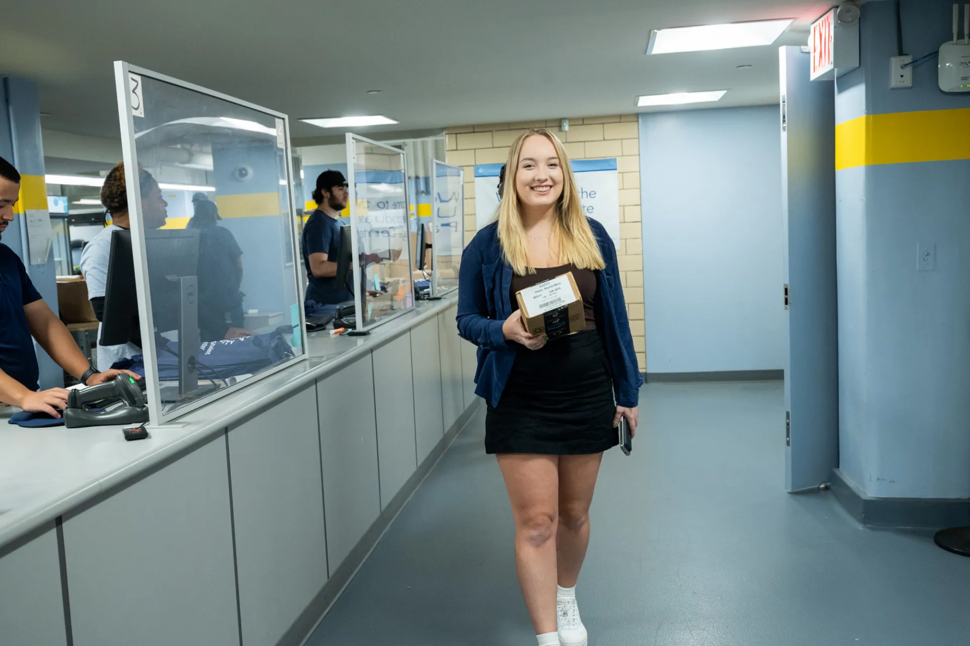 A student picks up a package at the mail center.