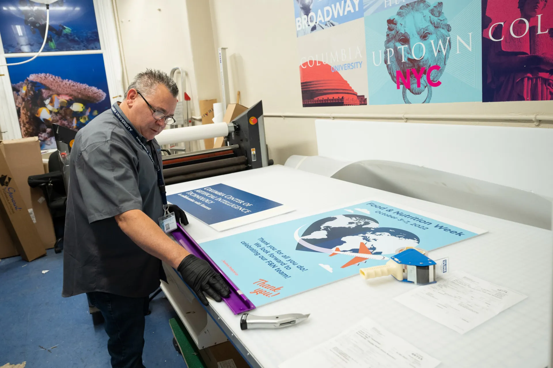 A Columbia Print employee measures two different posters.