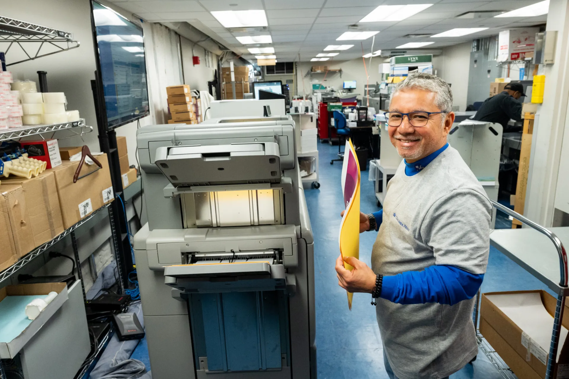 A Columbia Print employee holds some copies of a poster in the print shop.