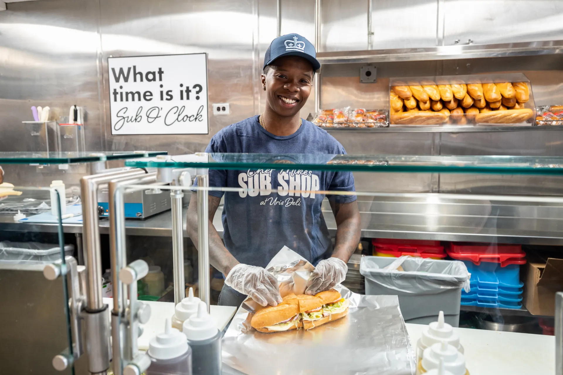 A Columbia Dining employee wraps out a sub and smiles.