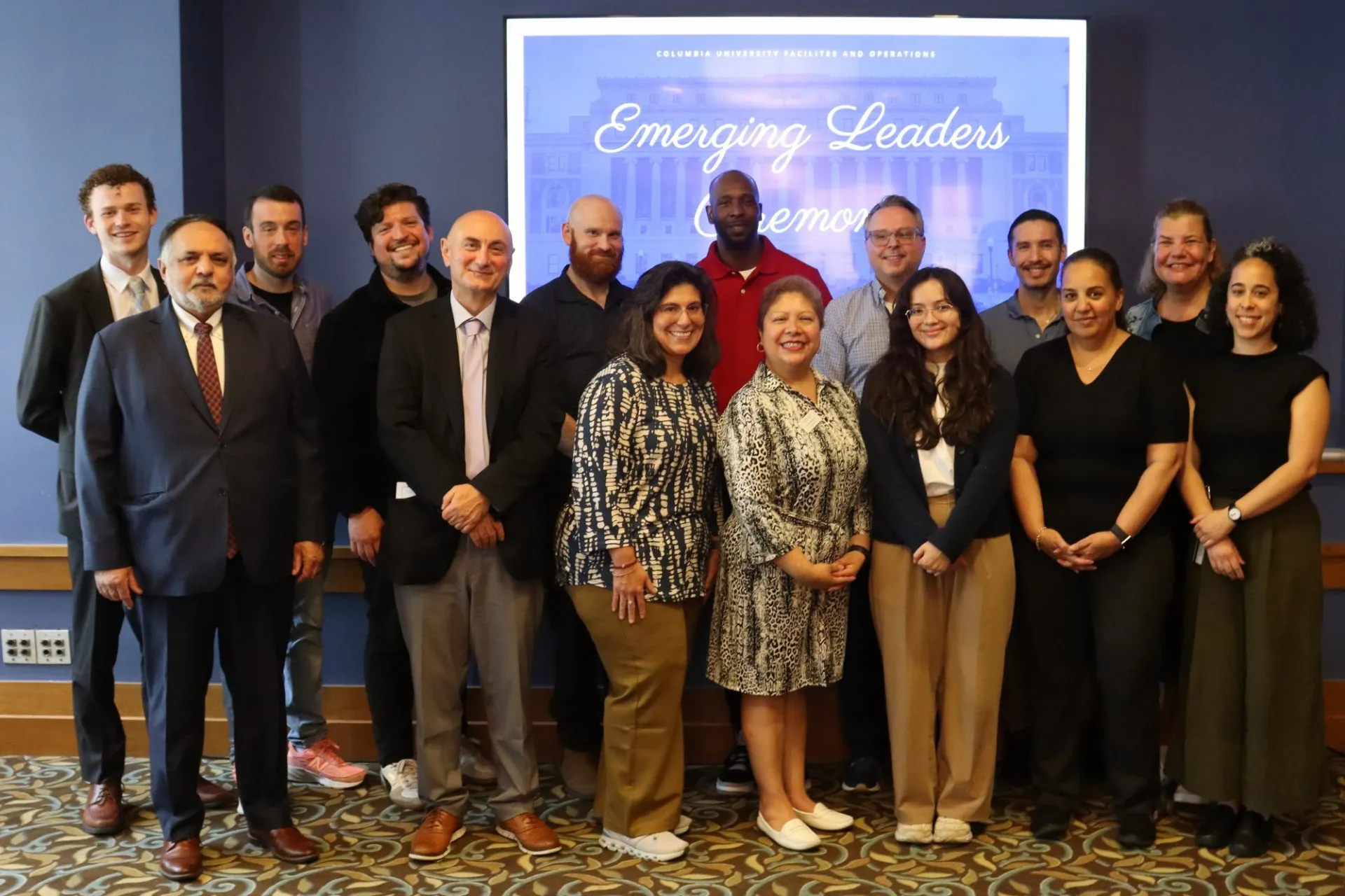 A group of people standing in front of a sign that reads "Emerging Leaders Ceremony."