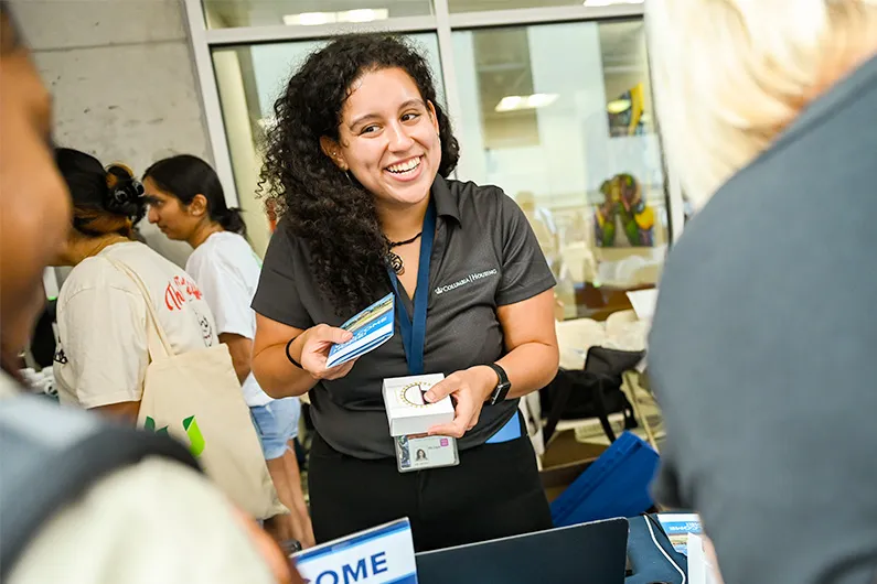 Mia DeLuis Zayas from Columbia Housing distributes brochures during move-in.