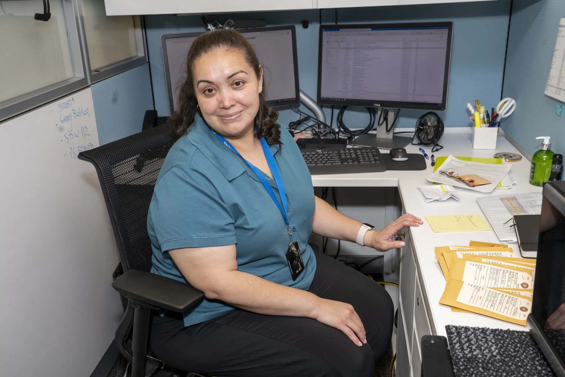 Sharon C. smiles from her desk.