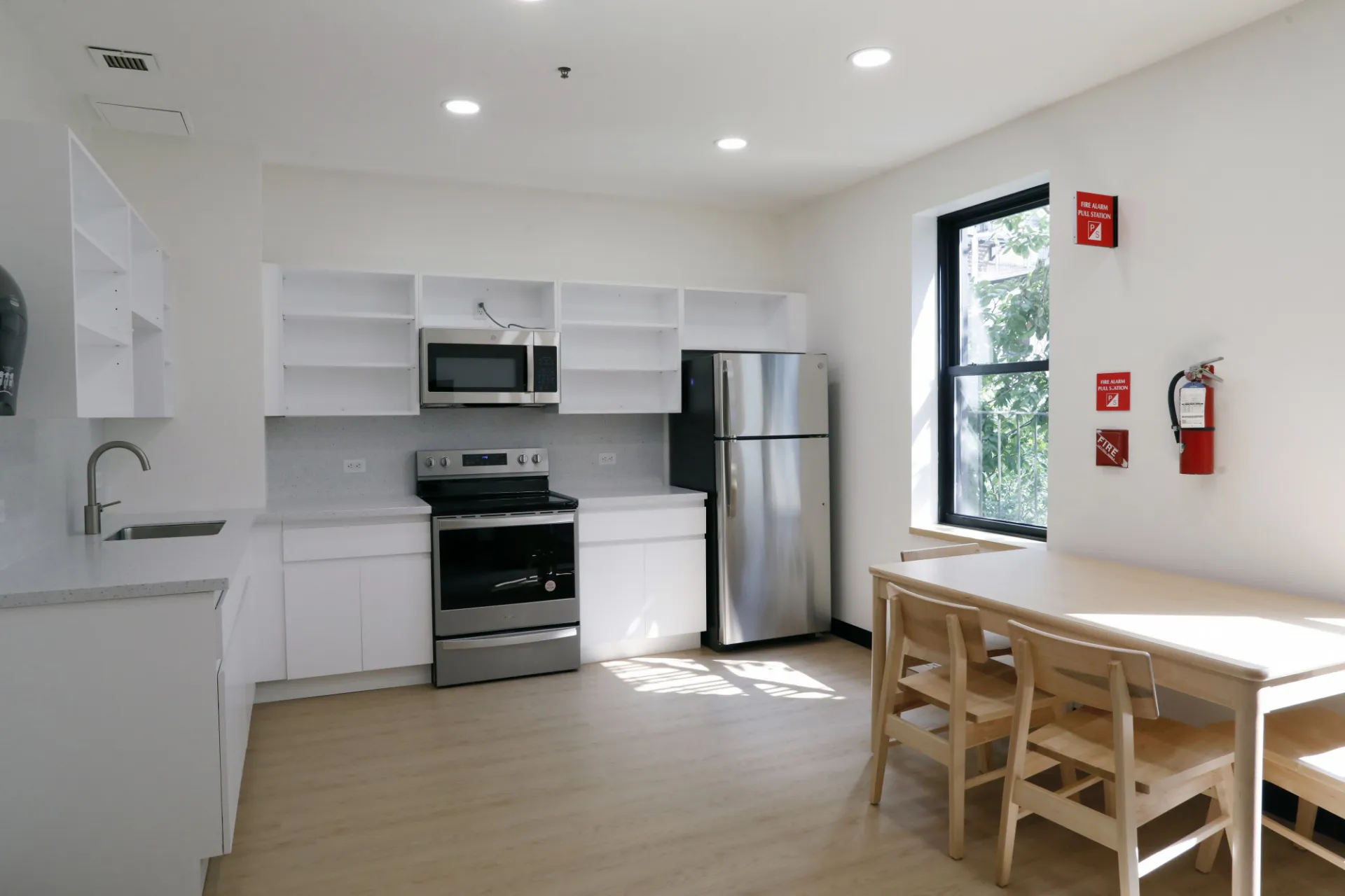 A refreshed kitchen in River Hall with white cabinetry and a light wood dining table set.
