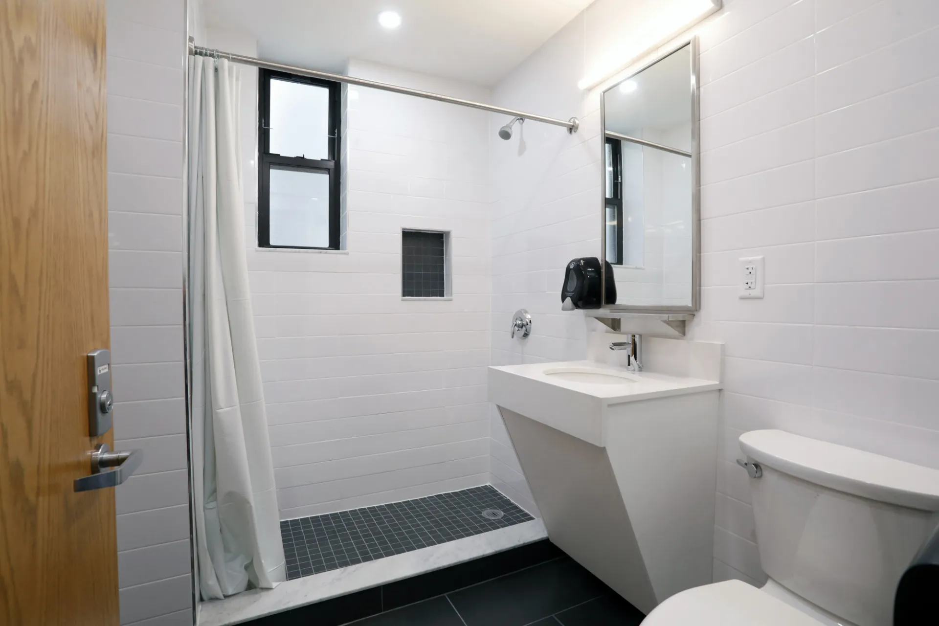 A refreshed bathroom in River Hall with white fixtures.